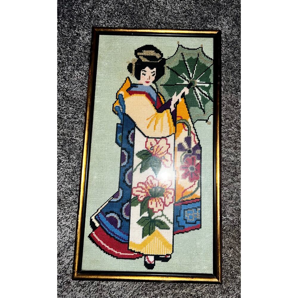 Frame Needlepoint Geisha Wall Hanging in gold tone frame.
